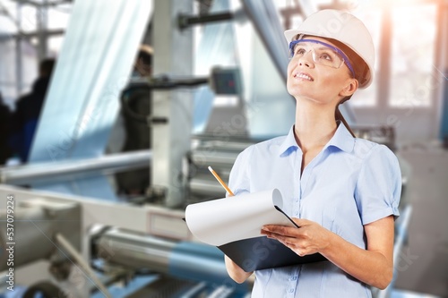 Young woman work with papers on factory background