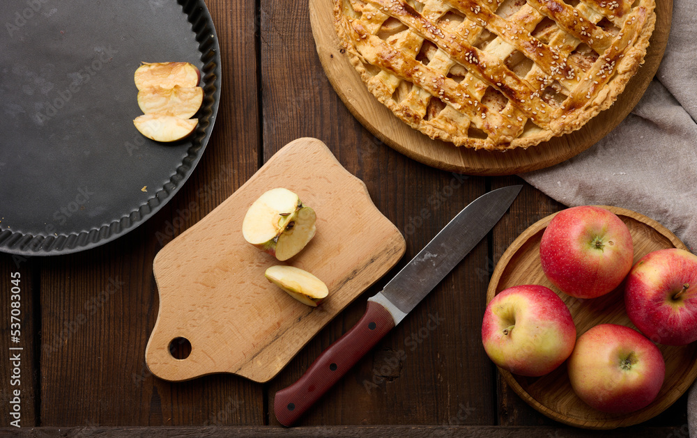 Round baked apple pie on a brown wooden table, top view Round baked apple pie on a brown wooden table, top view