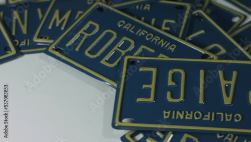 California License Plates Custom Names Rotate on White Surface 4K photo