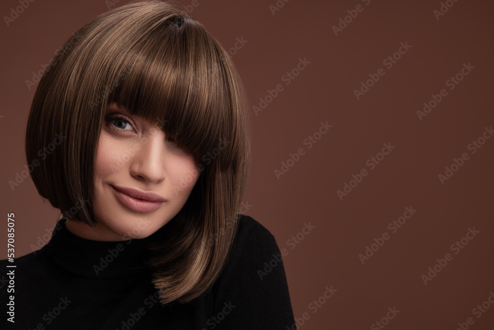Portrait of a beautiful brown-haired woman with a short haircut on a brown background Portrait of a beautiful brown-haired woman with a short haircut on a brown background