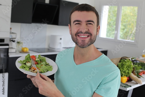 Handsome man eating a healthy salad 