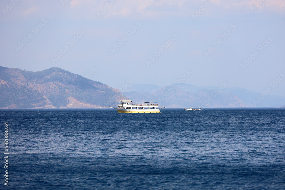 View to tourist boats in Mediterranean sea on mountains background View to tourist boats in Mediterranean sea on mountains background