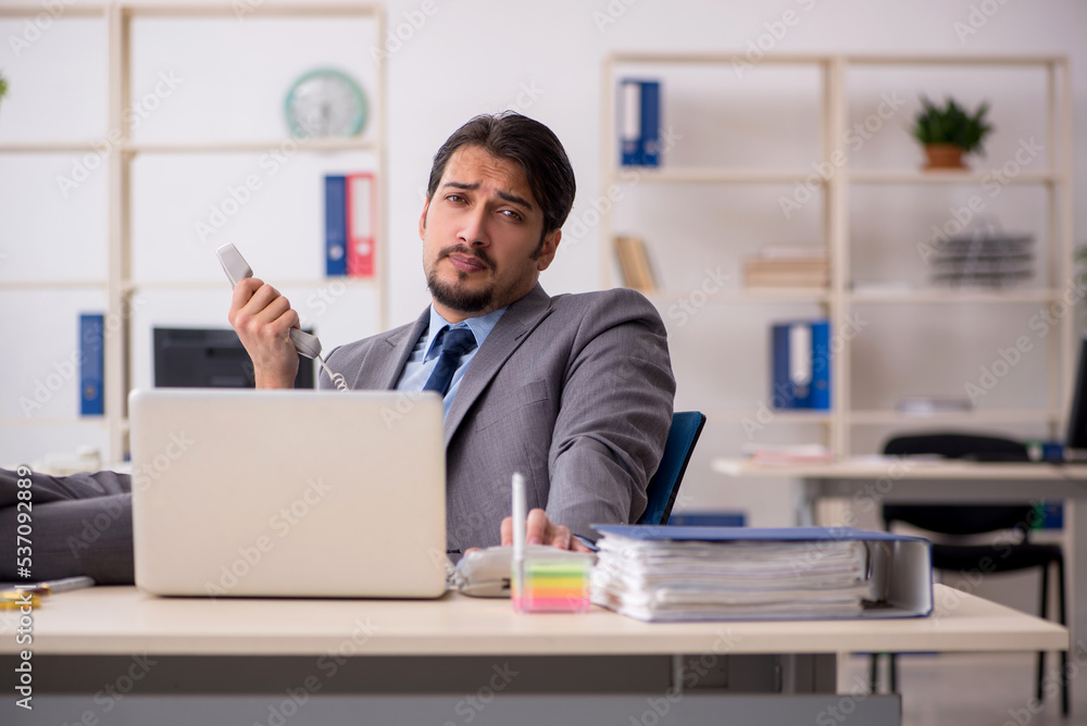 Young male employee working in the office Young male employee working in the office
