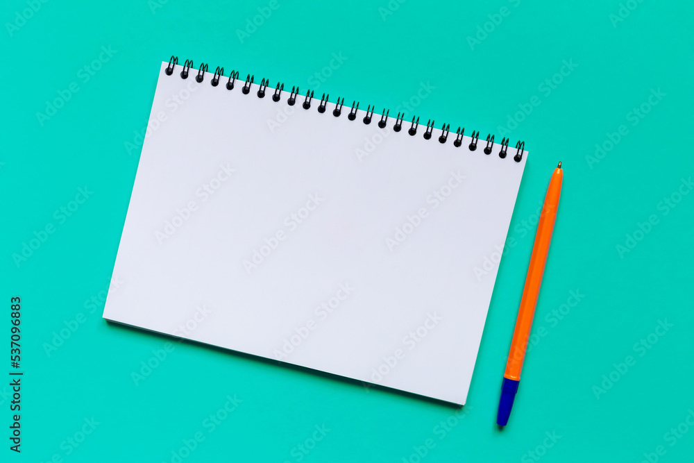 A sheet of paper and a pen on a turquoise background A sheet of paper and a pen on a turquoise background