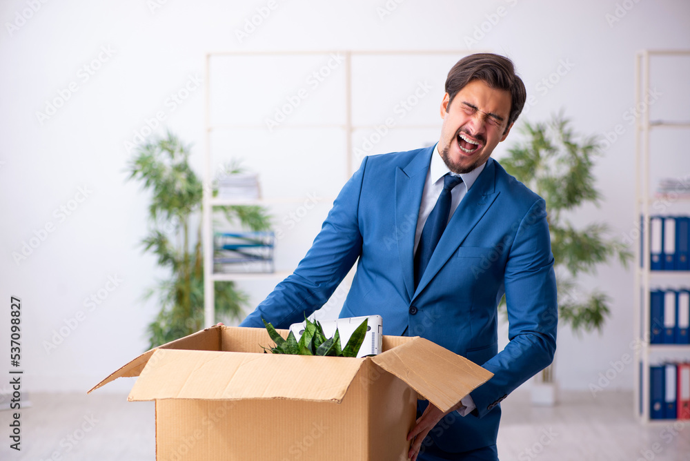 Young male employee in business relocation concept Young male employee in business relocation concept