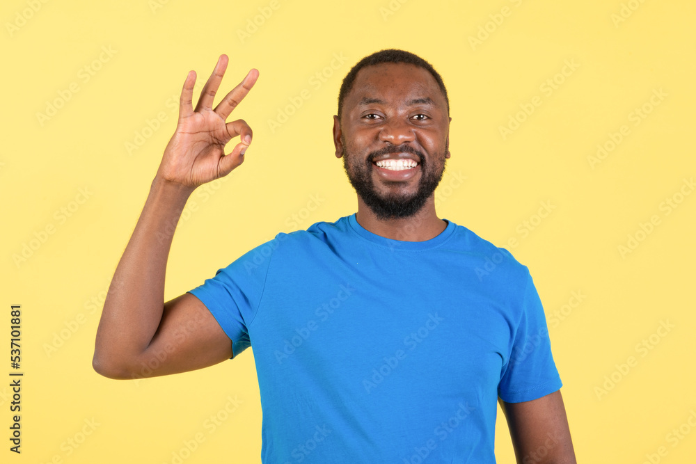 Happy Black Male Gesturing Okay In Approval Over Yellow Background Happy Black Male Gesturing Okay In Approval Over Yellow Background