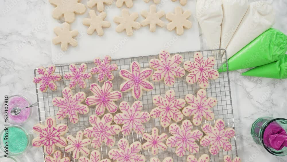 Flat lay. Step by step. Icing snowflake shaped sugar cookies with pink icing. Flat lay. Step by step. Icing snowflake shaped sugar cookies with pink icing.