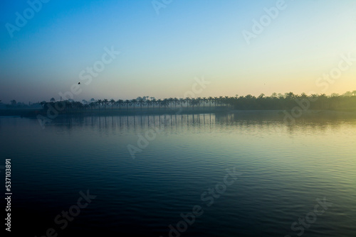 sunrise over the Nile river with reflection of palm trees