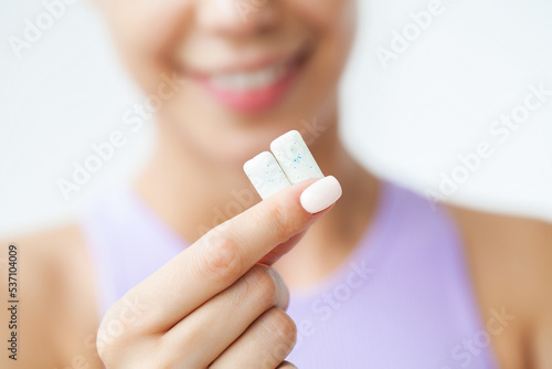 Smile young woman eating white chewing gum