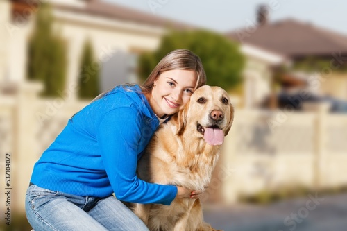 Happy young woman play with a dog outdoors