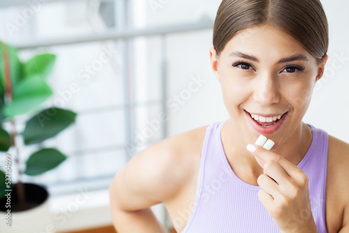 Smile young woman eating white chewing gum