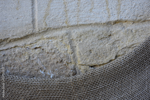 A half covered sack on a stone wall, surface view. Background, copy space, wallpaper. 