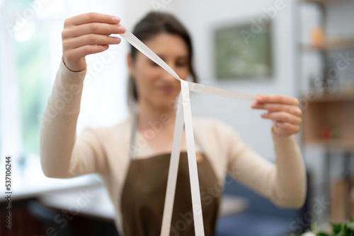 Woman hands wrapping a present in a box while working in the shop