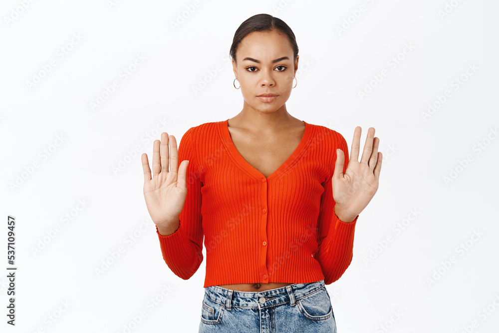 Serious young black woman showing stop gesture, raising palms hands up ...