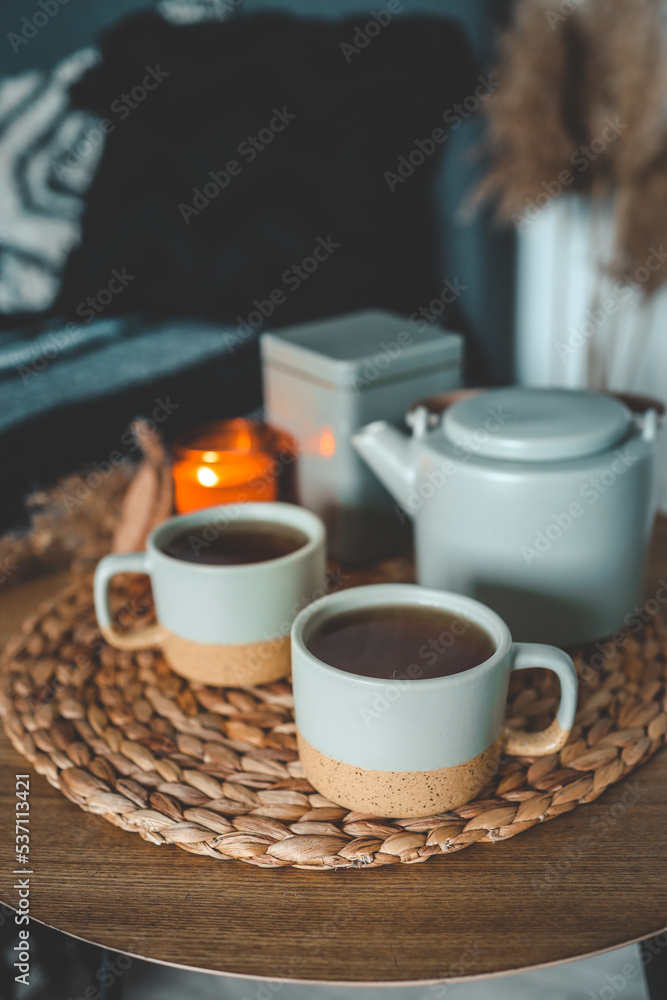 Two cups of tea, a kettle and a burning candle in the bedroom, home interior