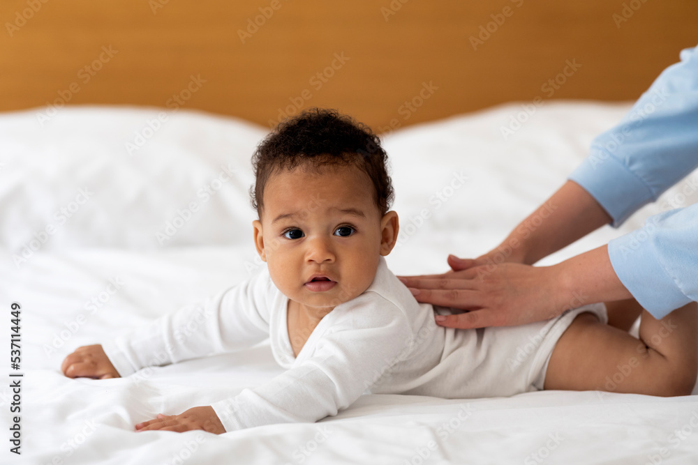 Child Care Concept. Mother Making Back Massage To Cute Black Baby Boy Child Care Concept. Mother Making Back Massage To Cute Black Baby Boy