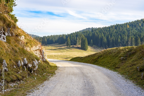 Winding gravel road in the mountains at sunset in autumn