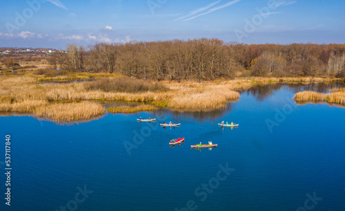 Tourists on colorful kayaks float on the river