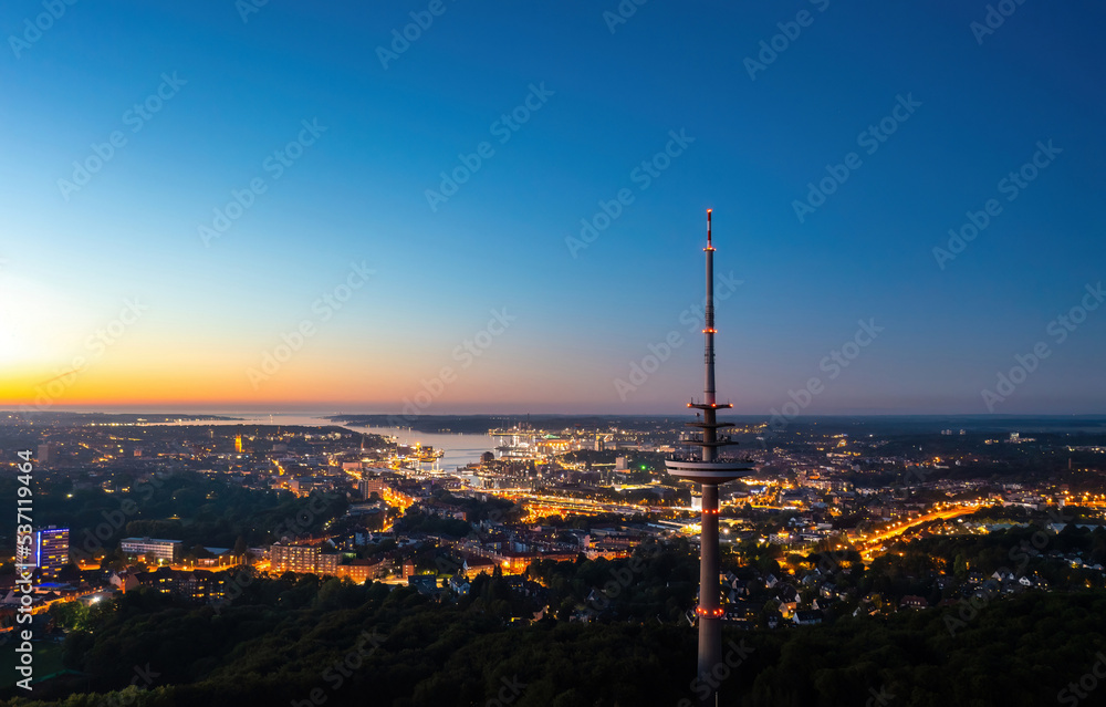 Aerial night skyline panorama of Kiel (Schleswig-Holstein, Germany). Fernmeldeturm in the foreground