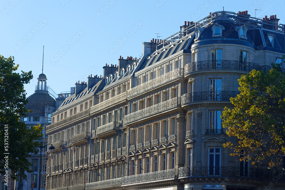 The facades of traditional French houses with typical balconies and windows. Paris.
