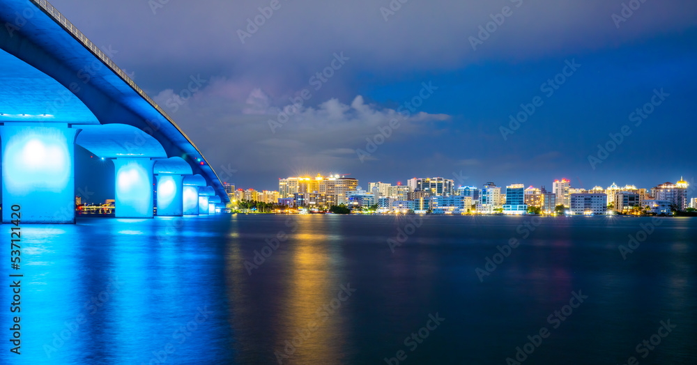 Sarasota Florida city lights at dusk with the Ringling Bridge lit up blue. 