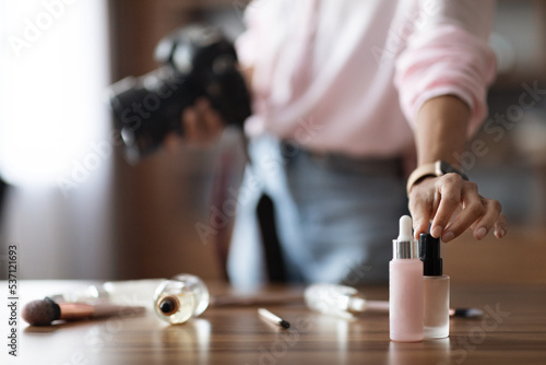 Unrecognizable woman beauty blogger taking photo of cosmetics, using camera