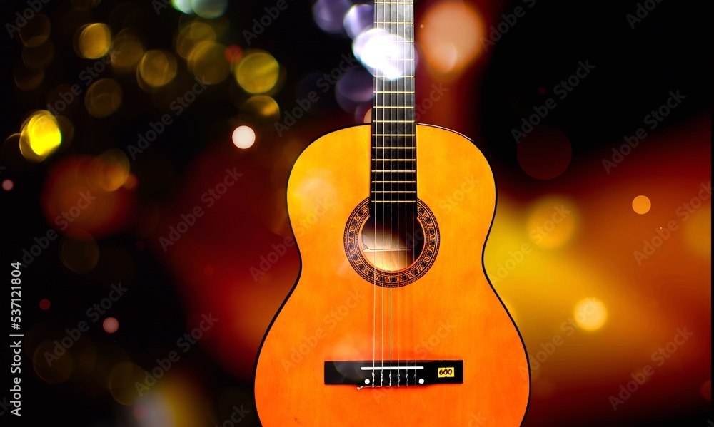 Classic acoustic guitar and colorful lights on background