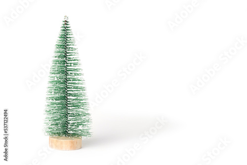 Green vintage bottle brush Christmas tree on a white background.  Miniature Christmas tree in the shape of a triangular brush on a wooden round stand. Front view. Copy space for holiday text.