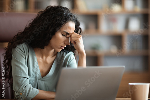 Unhappy lady suffering from migraine, working at office, copy space