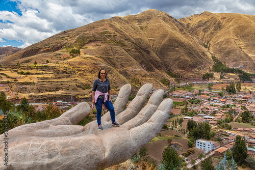 A woman at the Mirador de Cielo Punku viewpoint in Huaro, Cusco, Peru. This viewpoint consists of two hands reaching down into the valley. photo