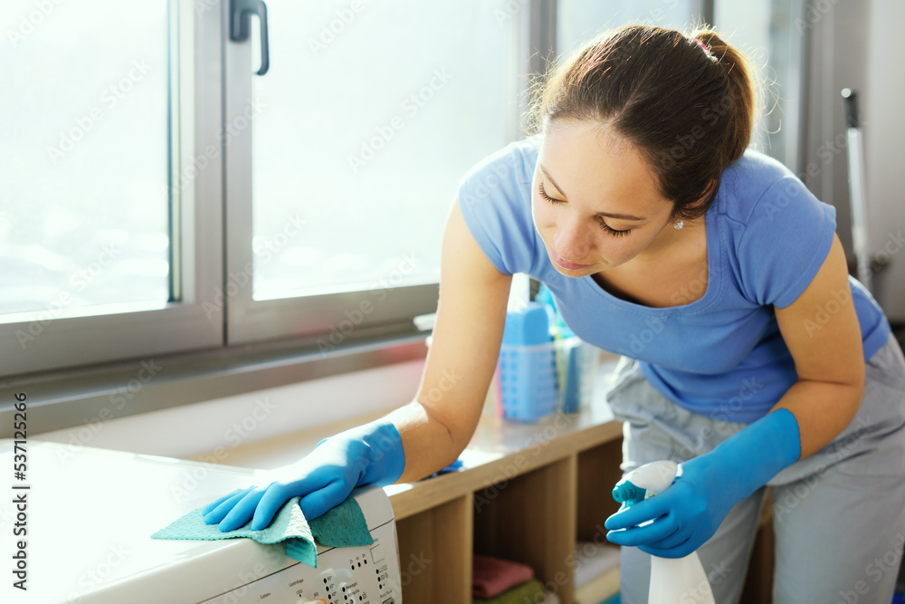 Woman cleaning a washing machine Woman cleaning a washing machine