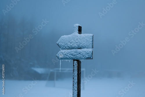 Closeup of a waypoint sign covered by snow during a heavy blizzard photo