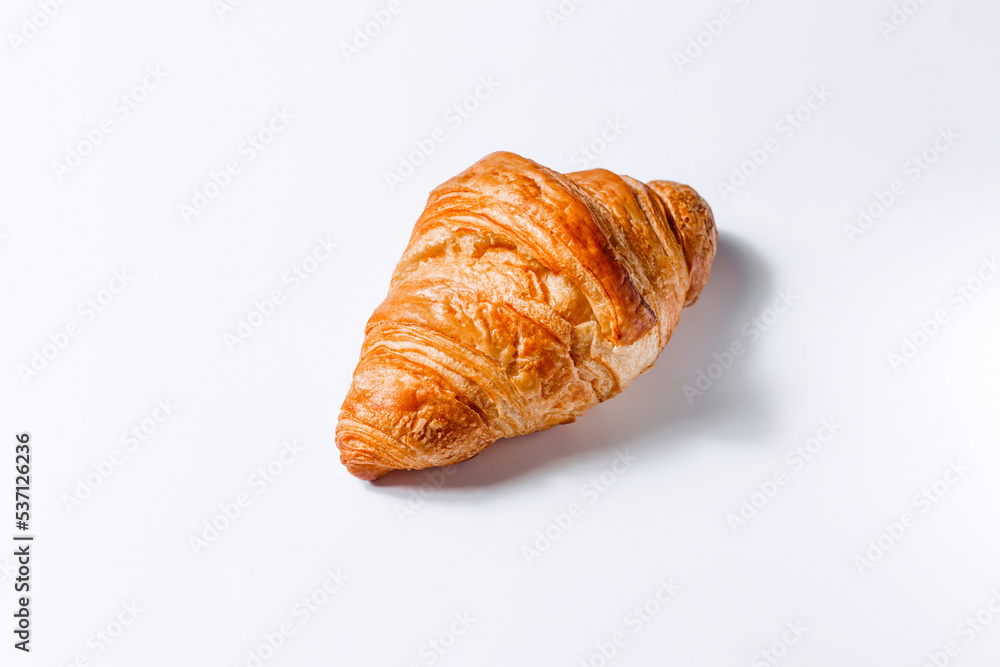 Fresh soft croissant on a white background with space for text. Stylish concept of pastries and breakfasts. Golden French croissant side view Fresh soft croissant on a white background with space for text. Stylish concept of pastries and breakfasts. Golden French croissant side view
