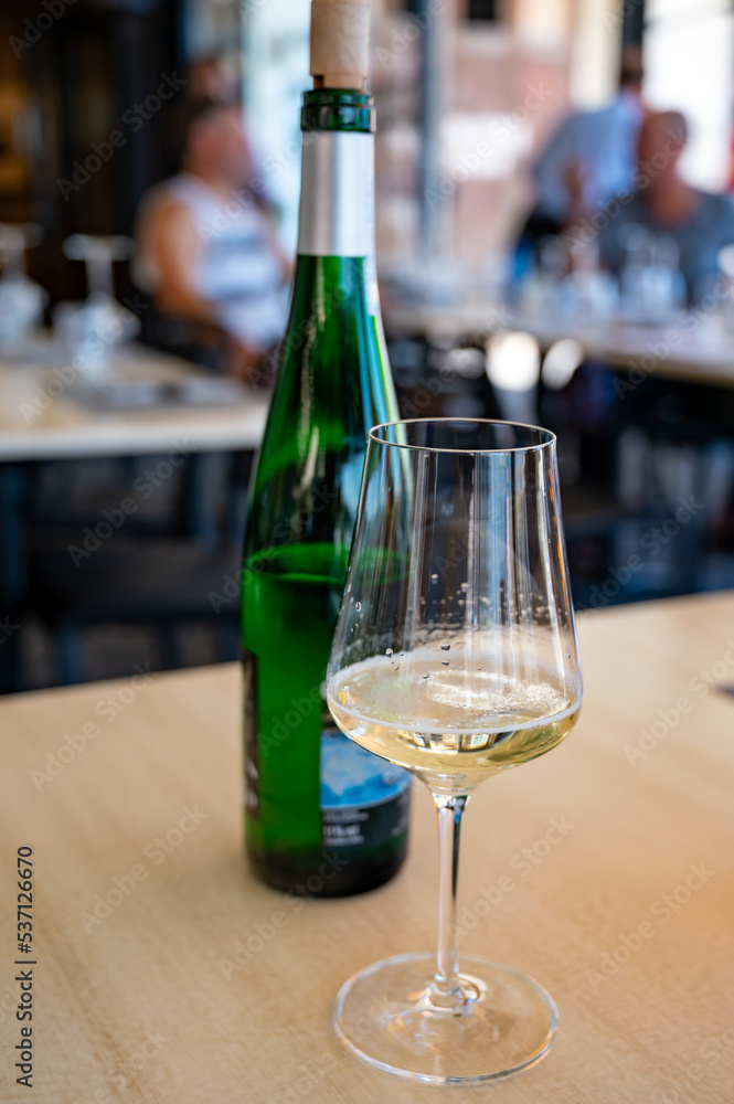 Drinking of txakoli or chacolí slightly sparkling very dry white wine produced in Spanish Basque Country, served in restaurant in Getaria, Spain