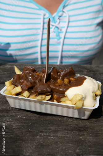 Lunch with traditional street food in Belgium, French fried potatoes with beef stew and mayonnaise photo