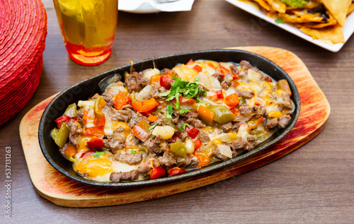 Appetizing Mexican alambre of grilled chopped beef meat with bacon, roasted peppers, onions and jalapenos