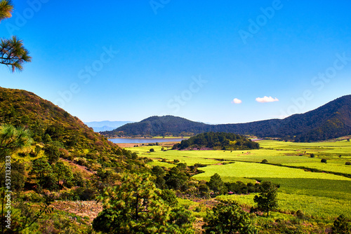 nature landscape with field of corn and mountains around, lake in the background in volcano crater of tepetiltic nayarit  photo
