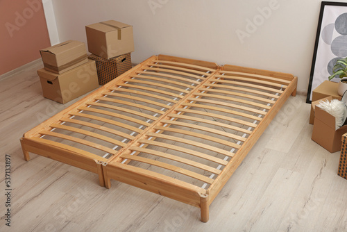 Wooden bed frame and cardboard boxes on floor in room