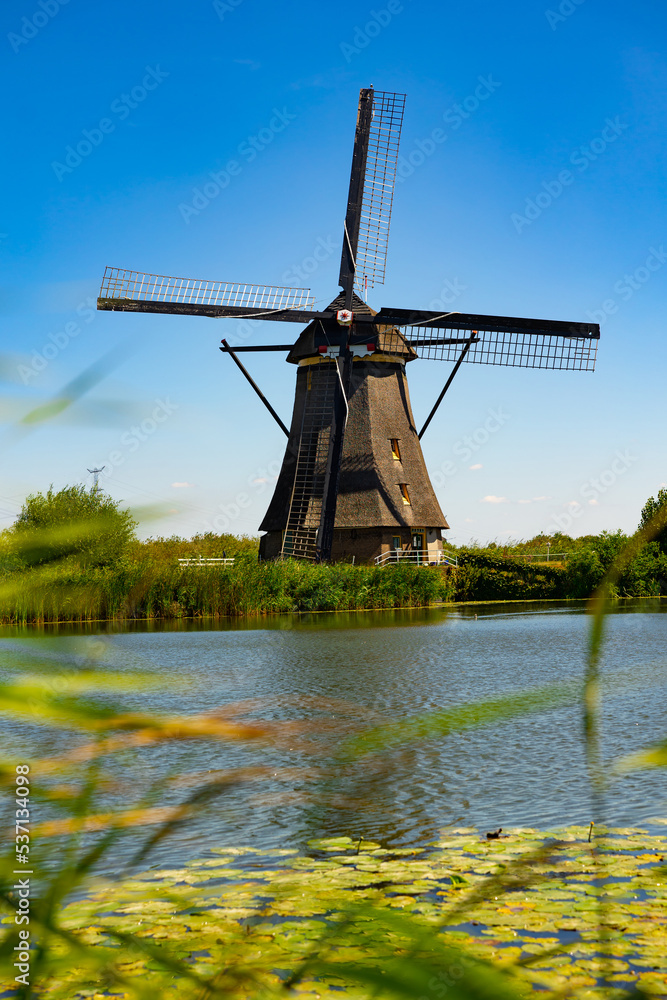 Serene landscape of windmill at Kinderdijk along riverside, province of South Holland, Netherlands.