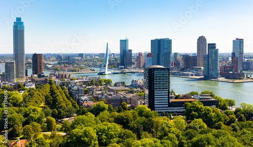 Scenic aerial view of modern cityscape of Rotterdam on both banks of Nieuwe Maas connected by Erasmus cable-stayed bridge on summer day, Netherlands..