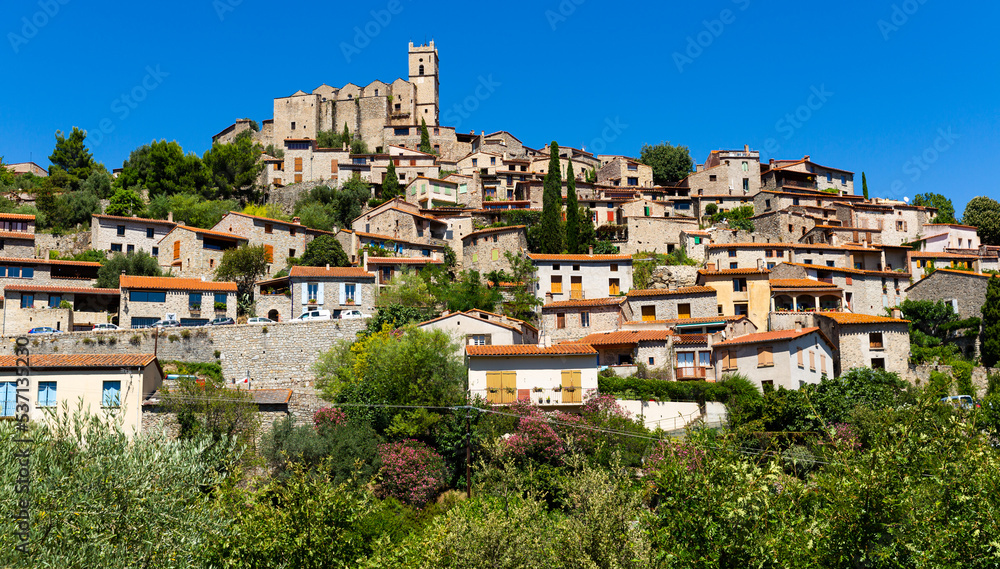 Picturesque view of small French village Eus surrounded by trees on hill