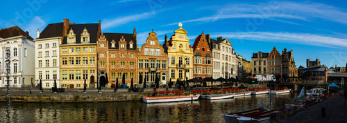 Picturesque summer view of Ghent with typical Flemish style townhouses located on banks of river Leie flowing through city center, Belgium.