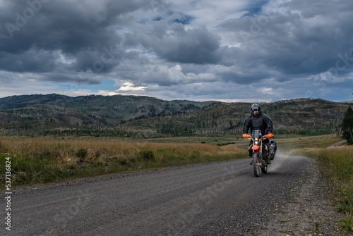 Off road motorcyclist riding on the continental Divide Ride in Colorado at dusk. 