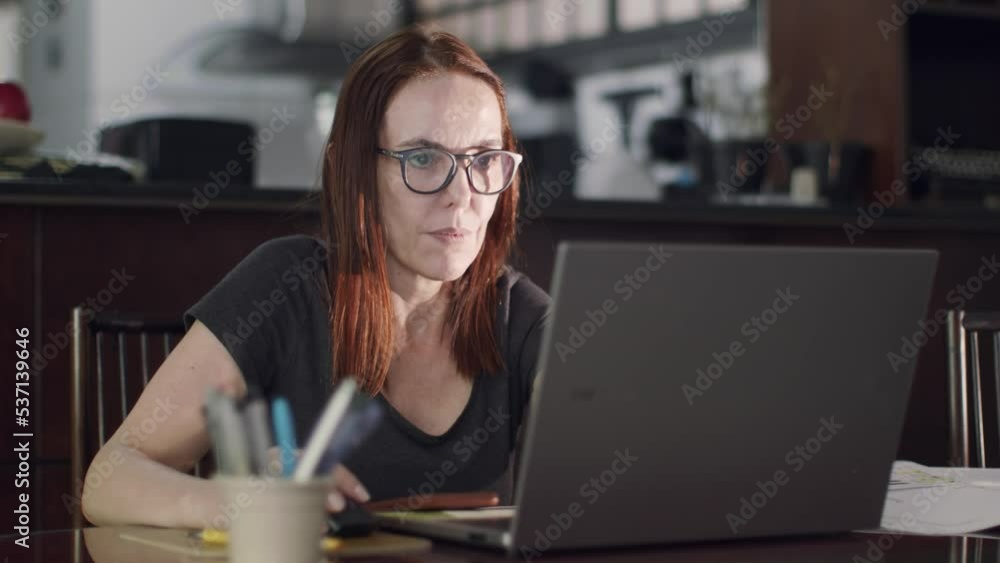 Female working from home. Woman browsing internet on her laptop. Female working from home. Woman browsing internet on her laptop.