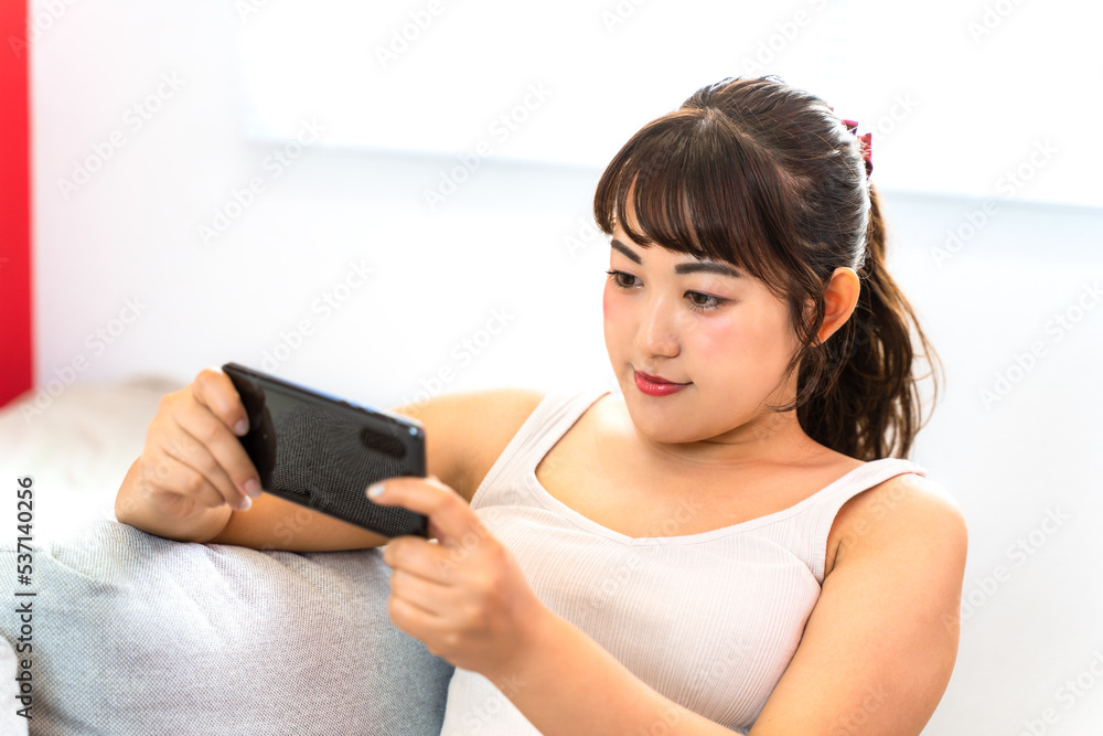 自宅でスマホを見る若い女性 自宅でスマホを見る若い女性