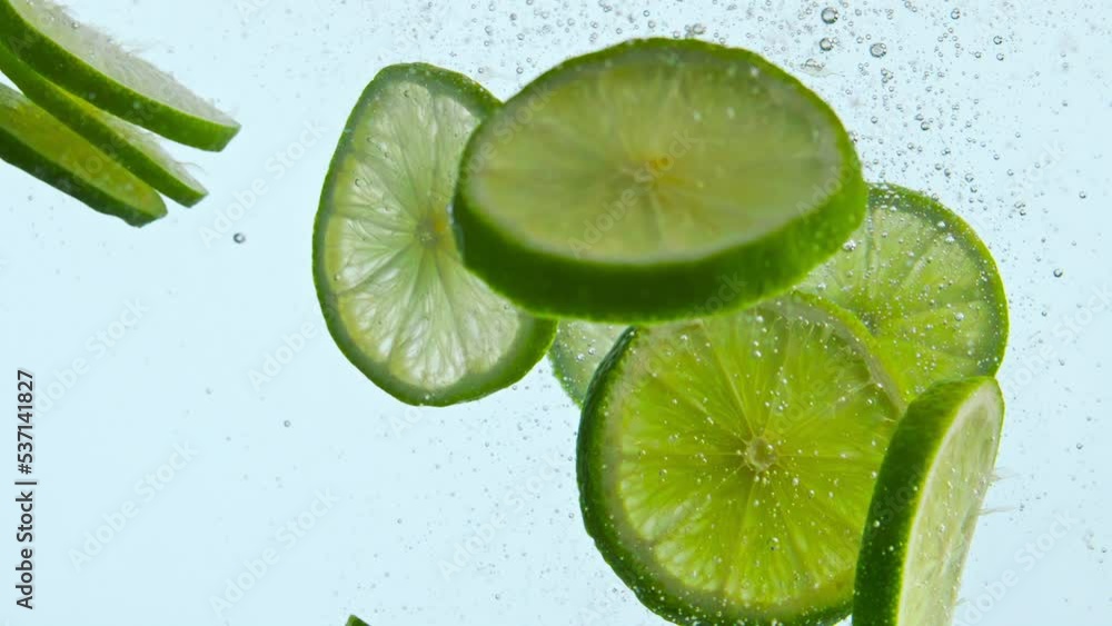 Fresh green lime underwater on white background close up. Citrus floating water Fresh green lime underwater on white background close up. Citrus floating water
