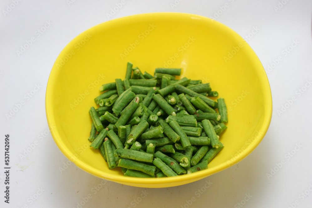 chopped long beans and put in a yellow bowl.Fresh yard long bean have sweet taste and crisp, high nutrition and vitamins. Food and vegetable concept. chopped long beans and put in a yellow bowl.Fresh yard long bean have sweet taste and crisp, high nutrition and vitamins. Food and vegetable concept.