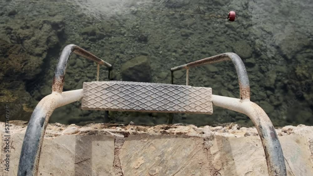 old metal rusty staircase in resort for descending into sea or ocean from shore. Transparent clean water for swimming, concept of travel to warm countries. old metal rusty staircase in resort for descending into sea or ocean from shore. Transparent clean water for swimming, concept of travel to warm countries.