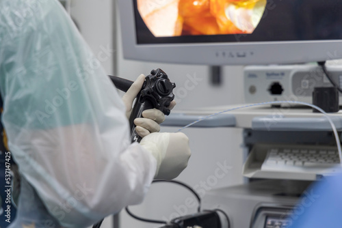 Close up photo of surgeon 's hands inside modern operating room in  surgical gown suit. Doctor using gastroscopy in dyspepsia patient with abdominal pain. photo