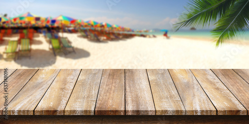 Empty of wooden table top with a coconut leaf background and blurred beach. For montage product display or design key visual layouts.